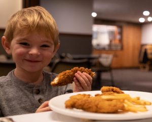 child eating chicken fingers