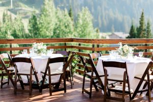 Outdoor tables set with brown chairs, white linens, and fresh flowers for Alta Lodge wedding